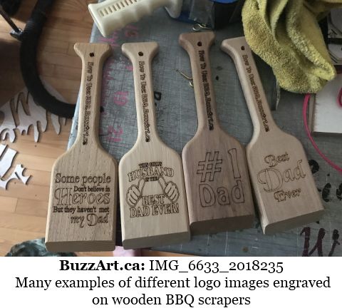 Many examples of different logo images engraved on wooden BBQ scrapers